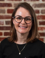 Woman wearing glasses and a wine colored blouse