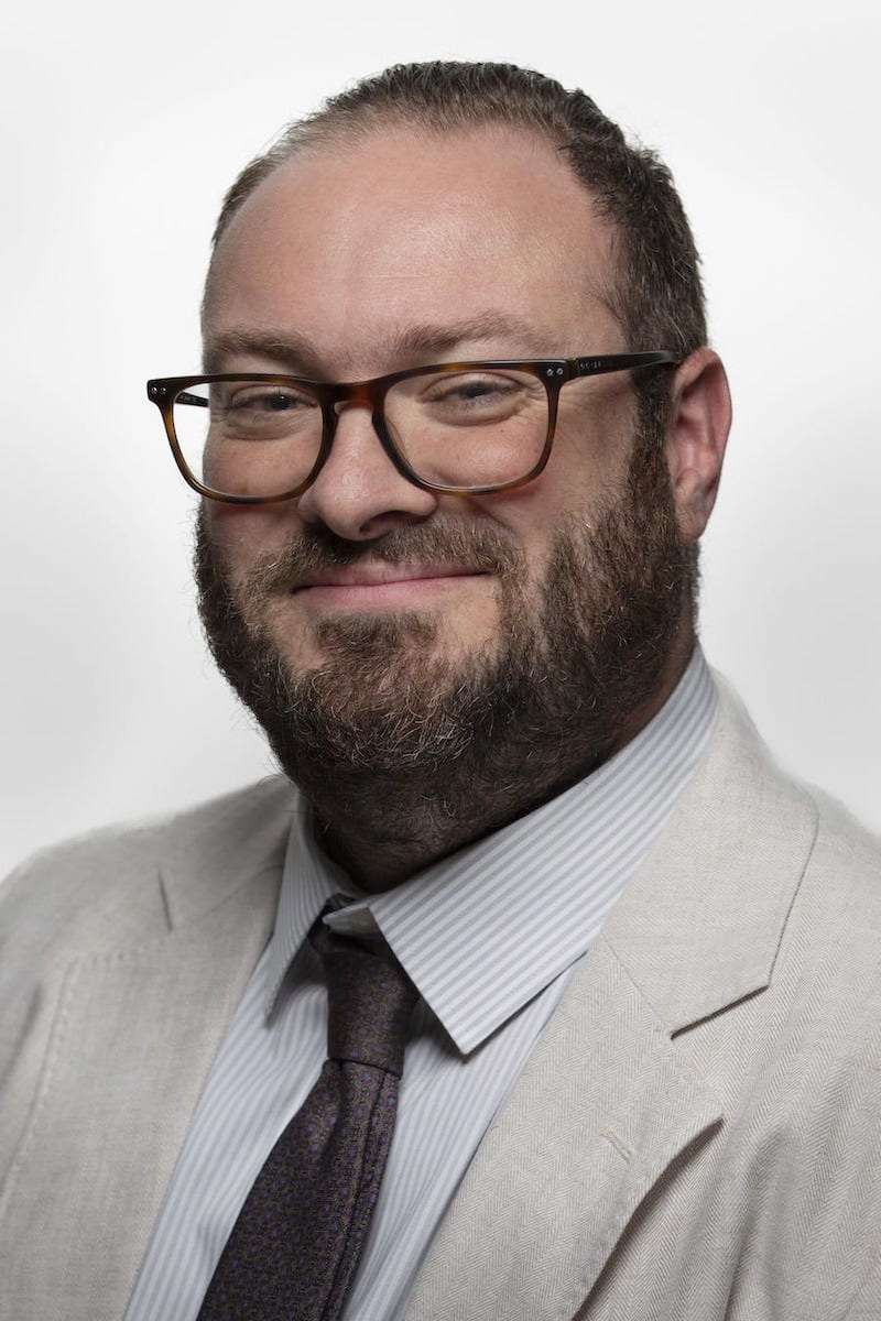 Man with glasses, dark hair, smiling