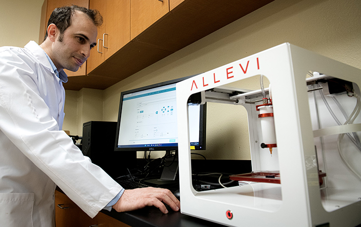 A man in a lab coat operates a 3D printer, focused on the intricate process of additive manufacturing.