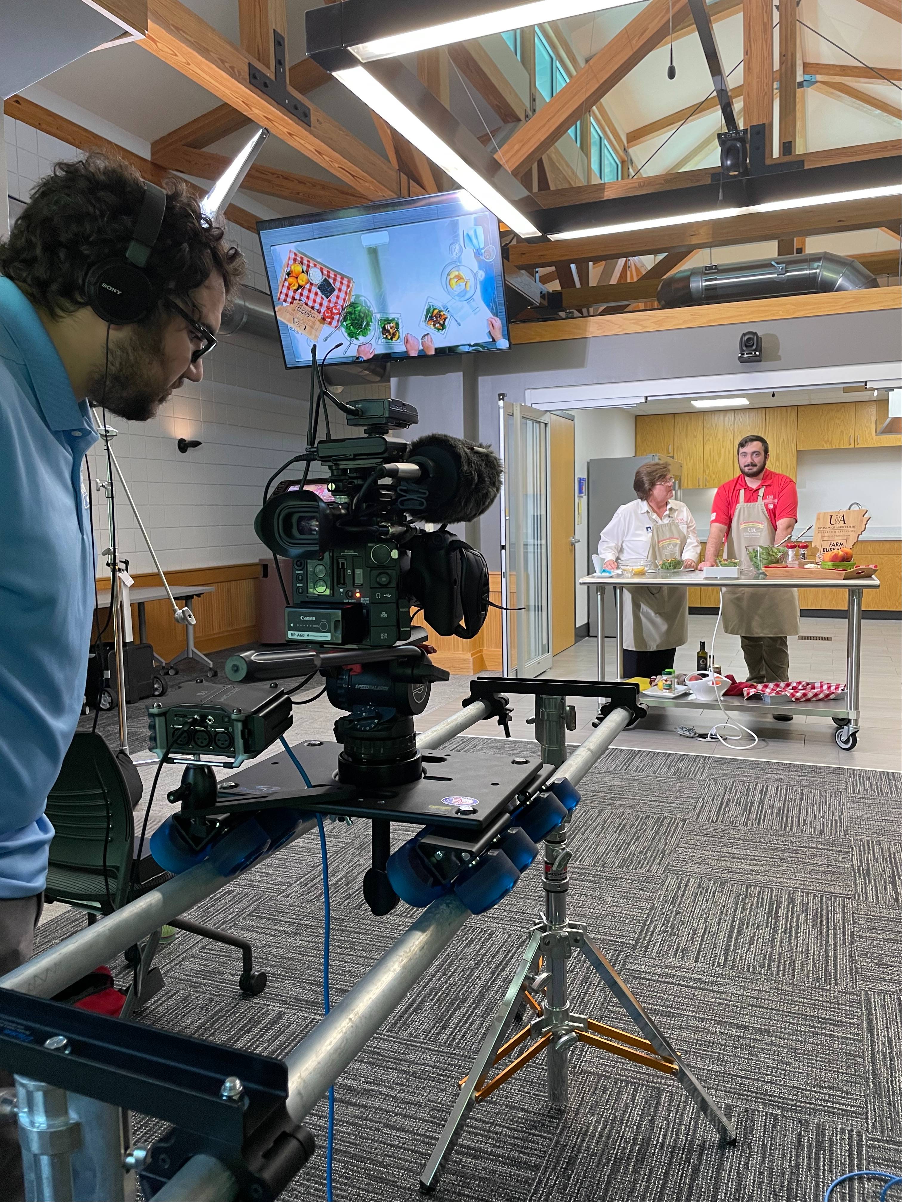 Behind the scenes of Arkansas Home Grown & Homemade A videographer looks a camera in the set of Arkansas Home Grown & Homemade
