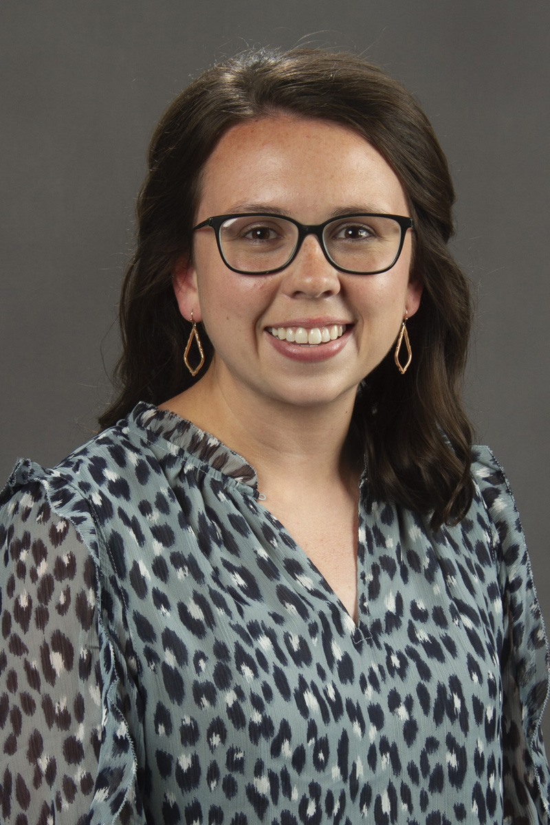 Woman with dark shoulder length hair wearing glasses.