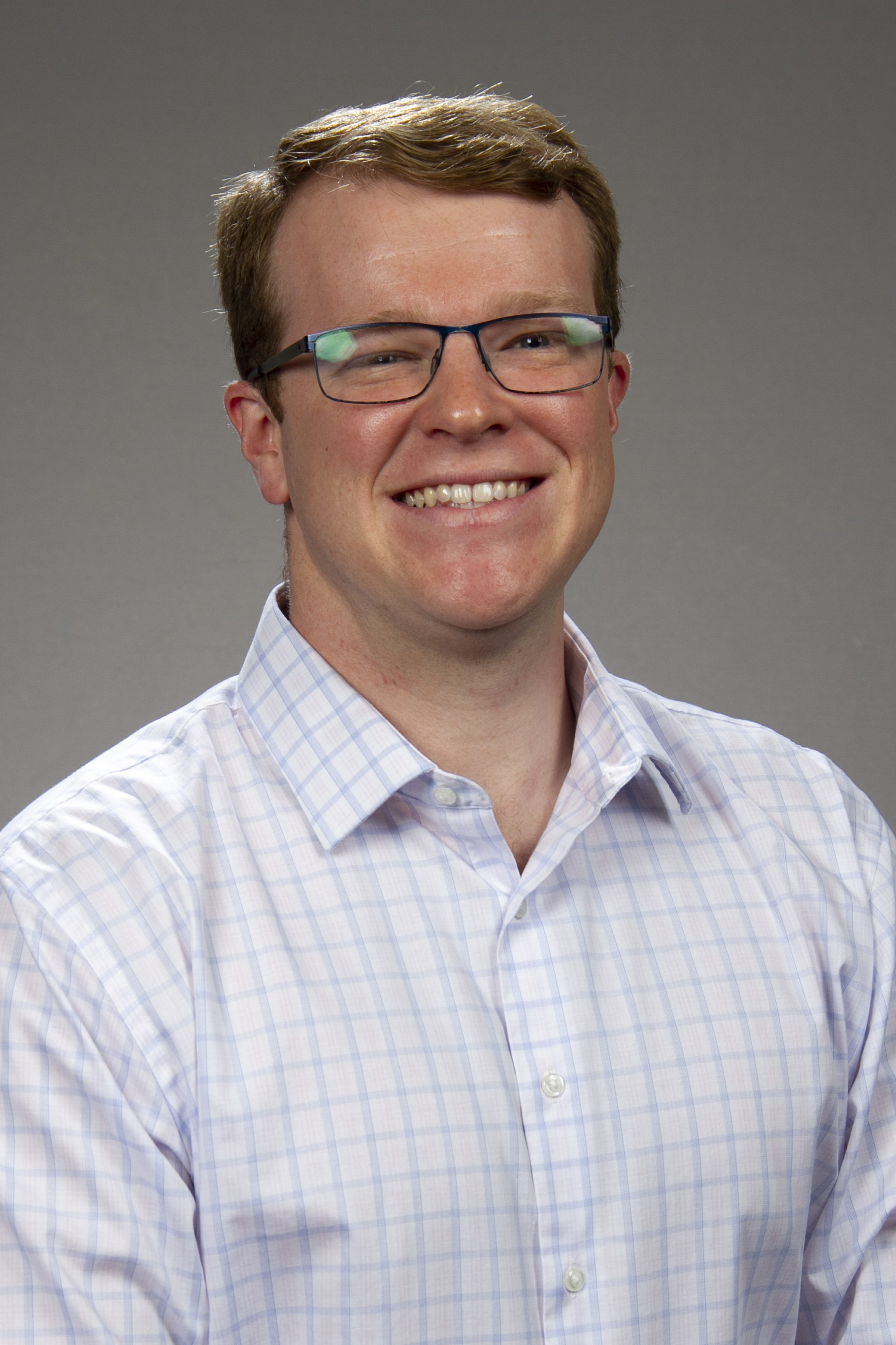 man with short hair and glasses, smiling