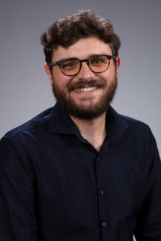 Man with dark hair, black-framed glasses