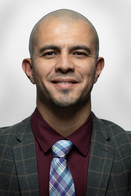 Portrait of a man with dark shirt, plaid tie